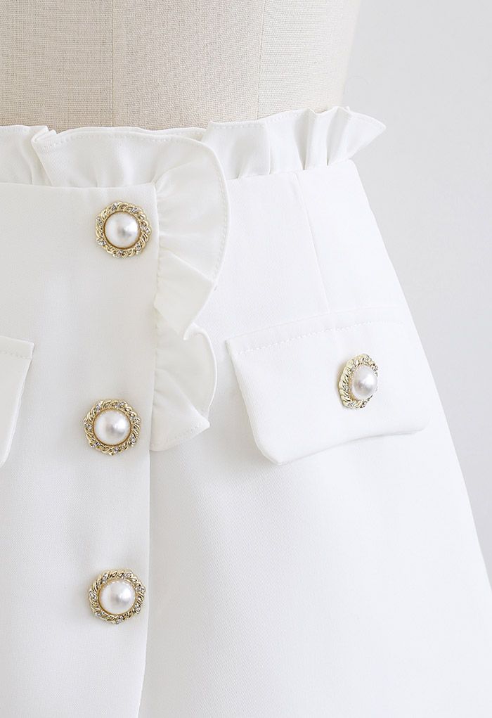 Falda pantalón con solapa y botones de perla con ribete de volantes en blanco