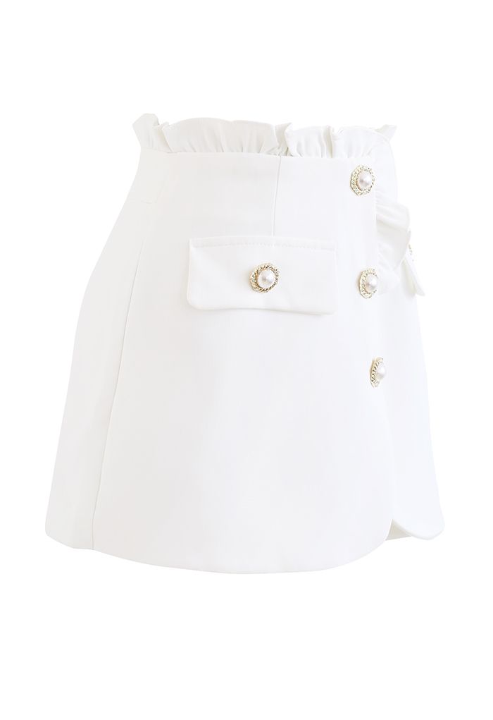 Falda pantalón con solapa y botones de perla con ribete de volantes en blanco