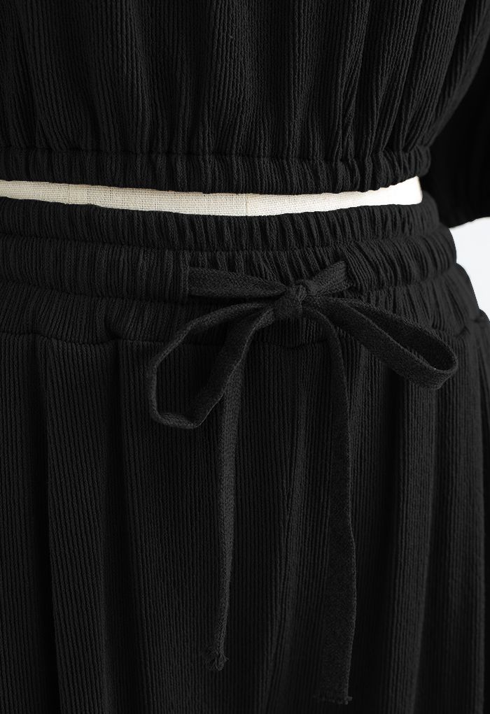 Conjunto de pantalón y top corto con hombros descubiertos en negro