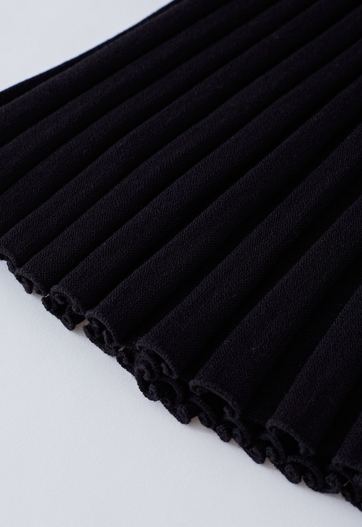 Conjunto de top corto de punto y falda con abertura abotonada en negro