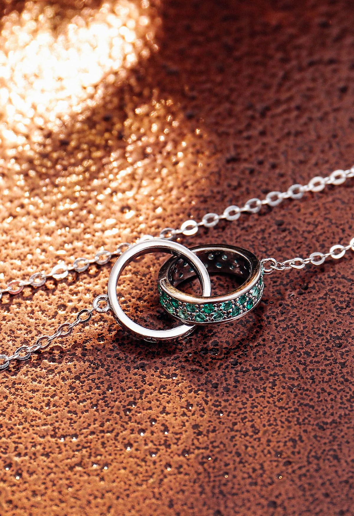 Collar con doble anillo adornado con esmeraldas