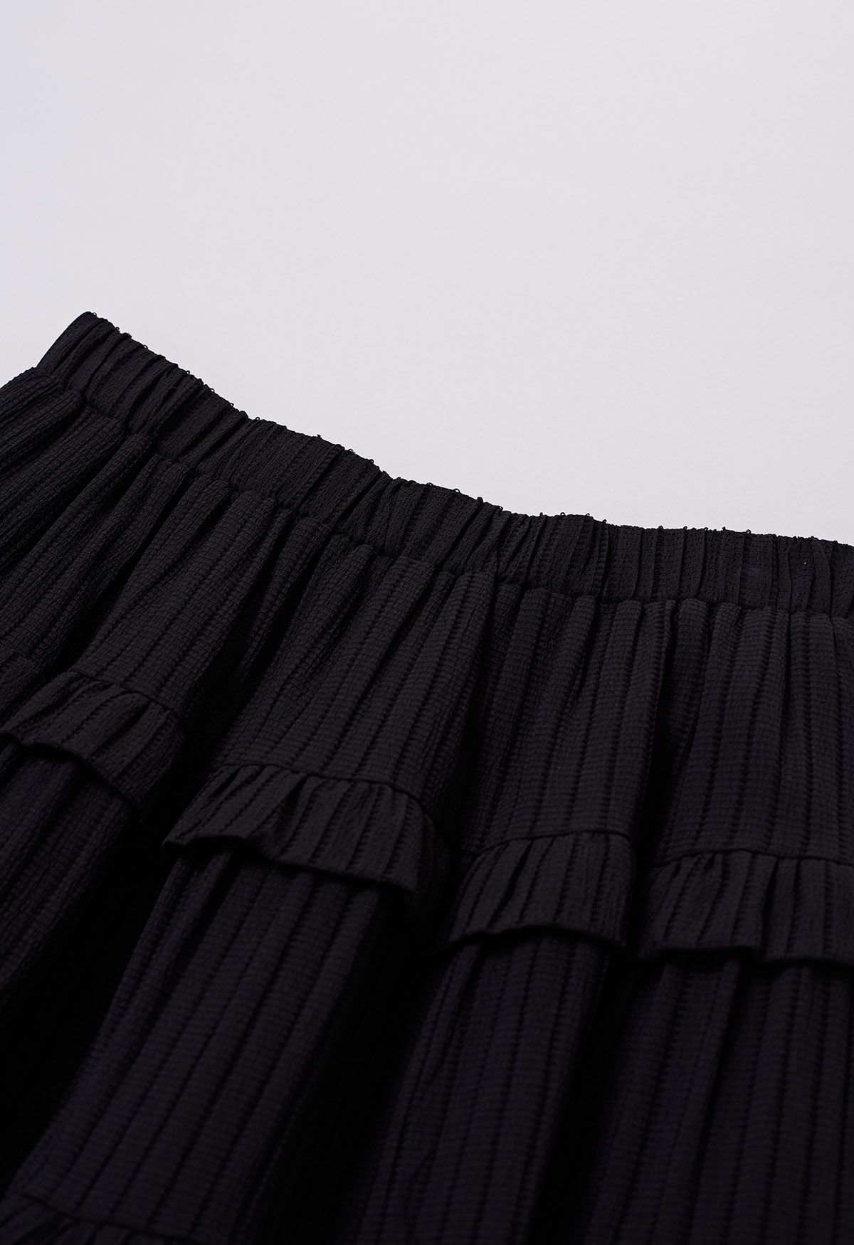Falda larga con textura de rayas escalonadas y volantes en negro