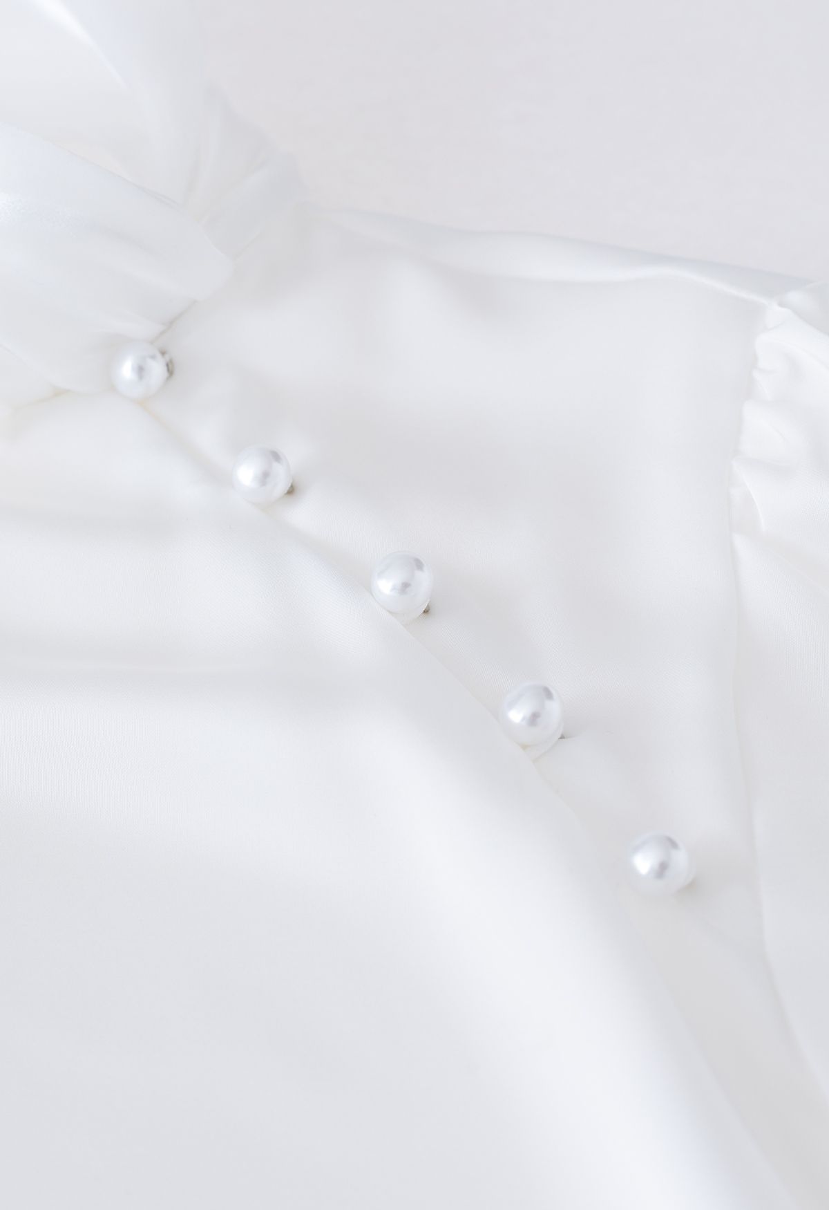 Camisa de raso de perlas con lazo de organza en blanco
