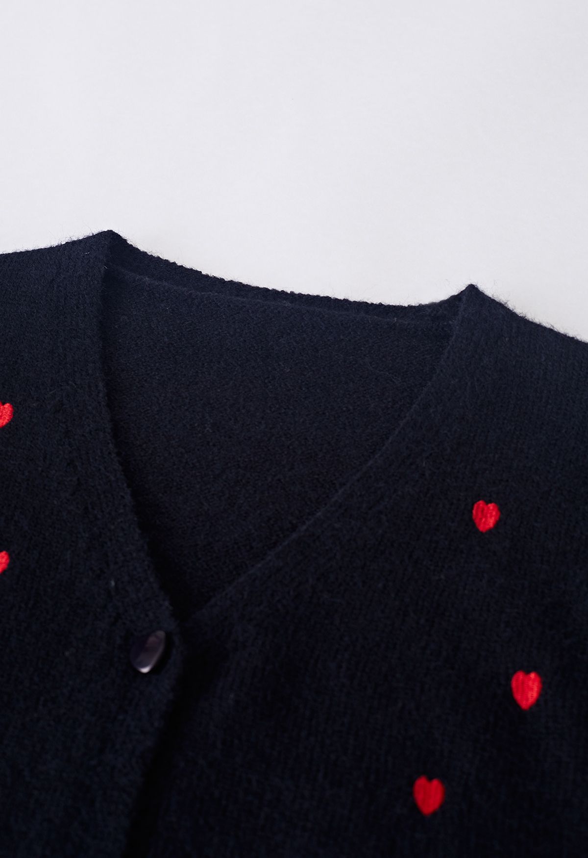 Cárdigan negro con botones y bordado de corazoncitos