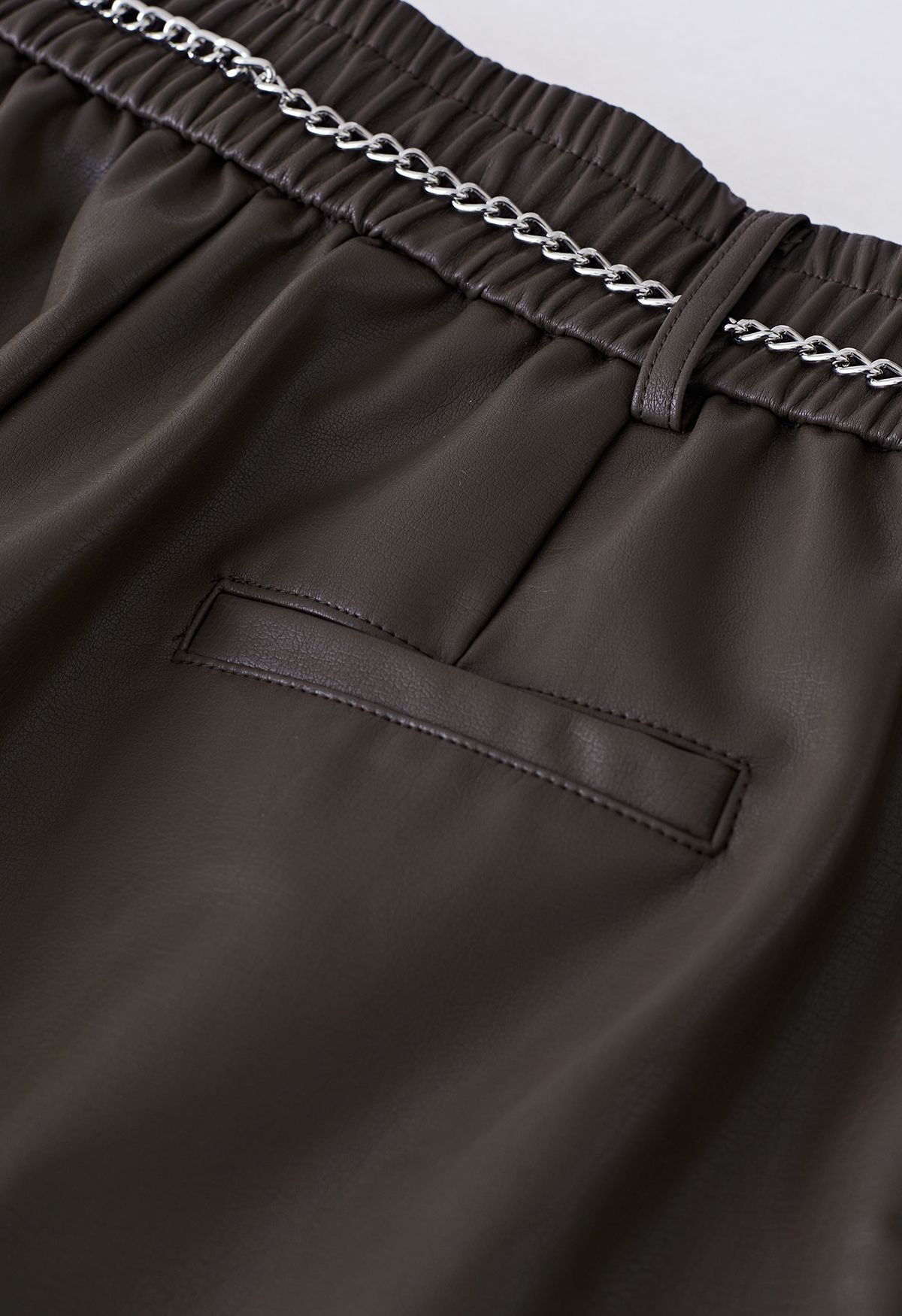 Shorts de cuero sintético con cadena plateada en marrón