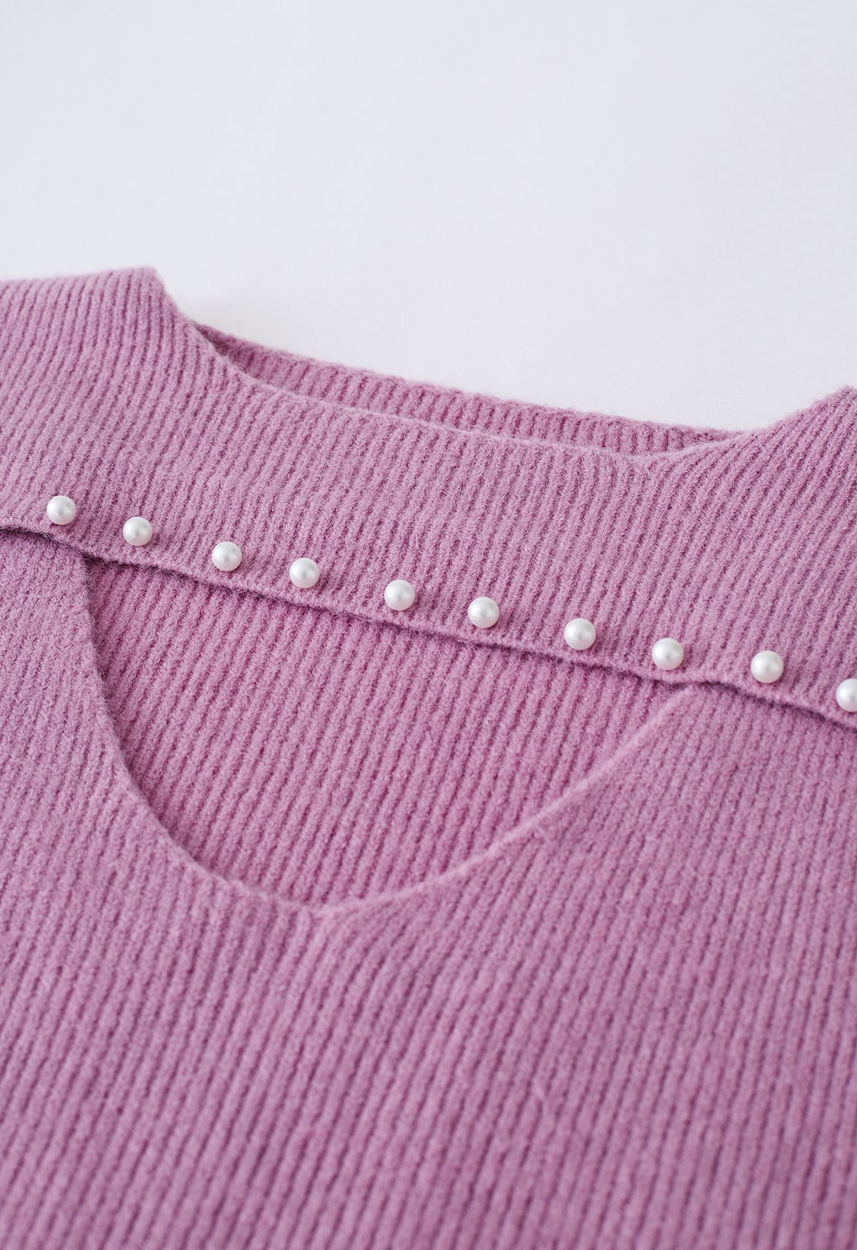 Suéter de punto con escote de perlas recortadas en rosa