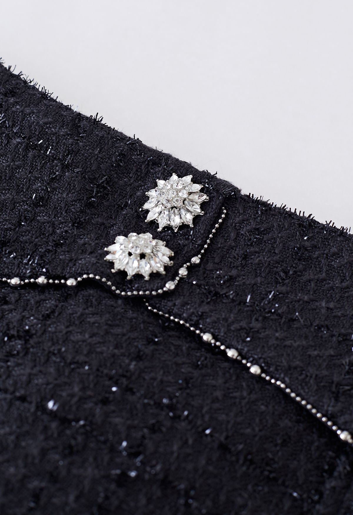 Minifalda de tweed con detalle de costuras con botones brillantes en negro