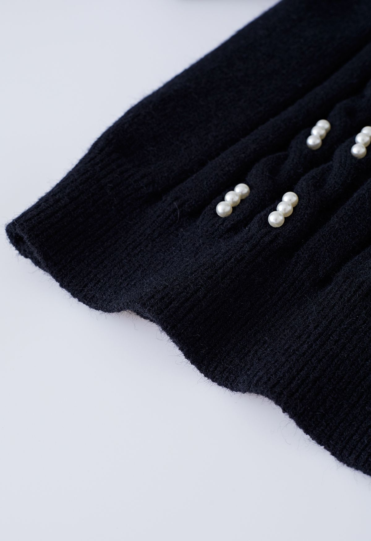 Top de punto trenzado adornado con perlas en negro