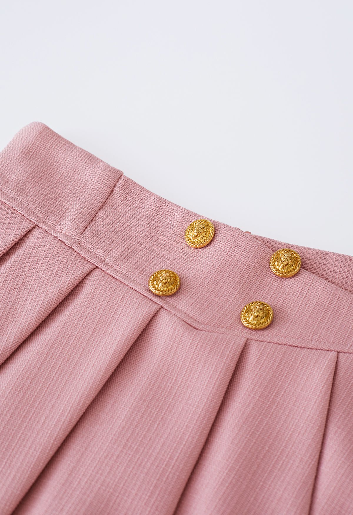 Minifalda de vuelo plisada con botones dorados en rosa