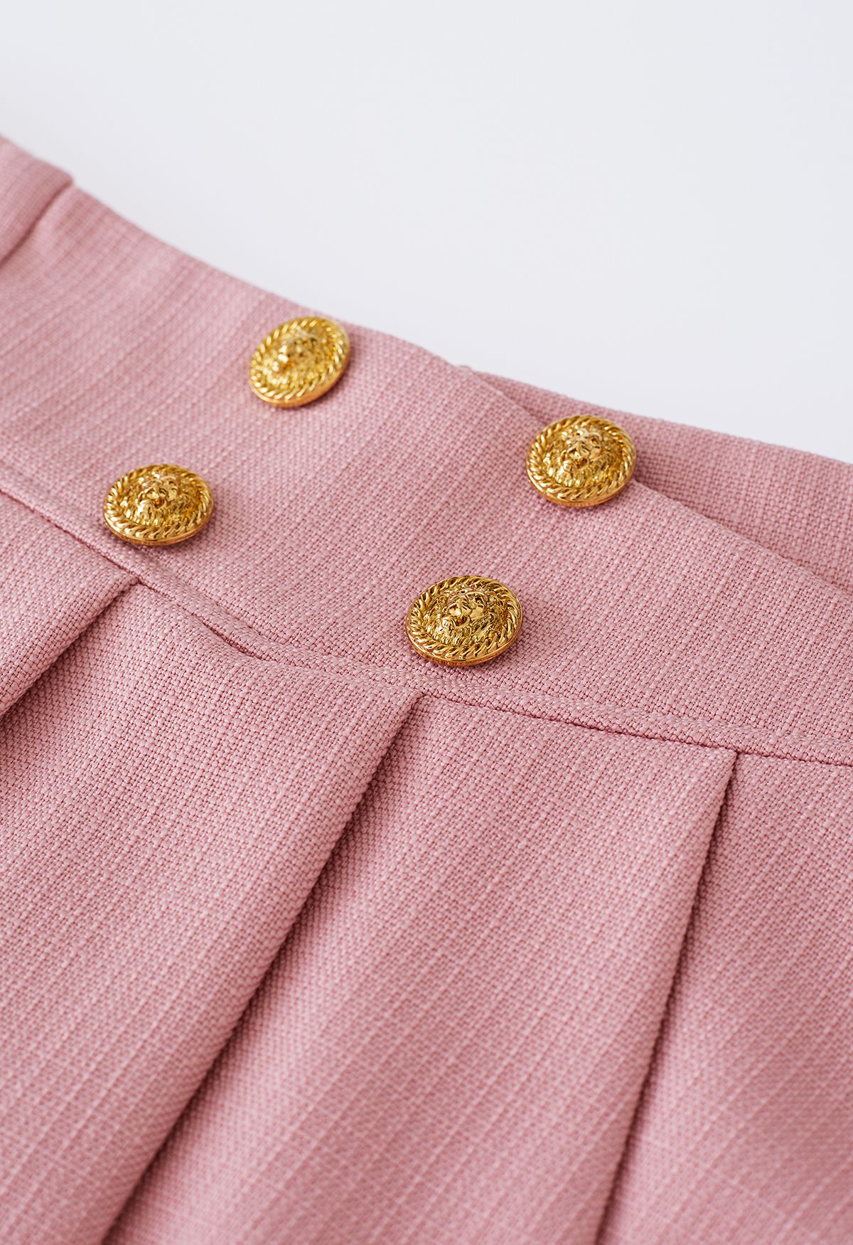 Minifalda de vuelo plisada con botones dorados en rosa