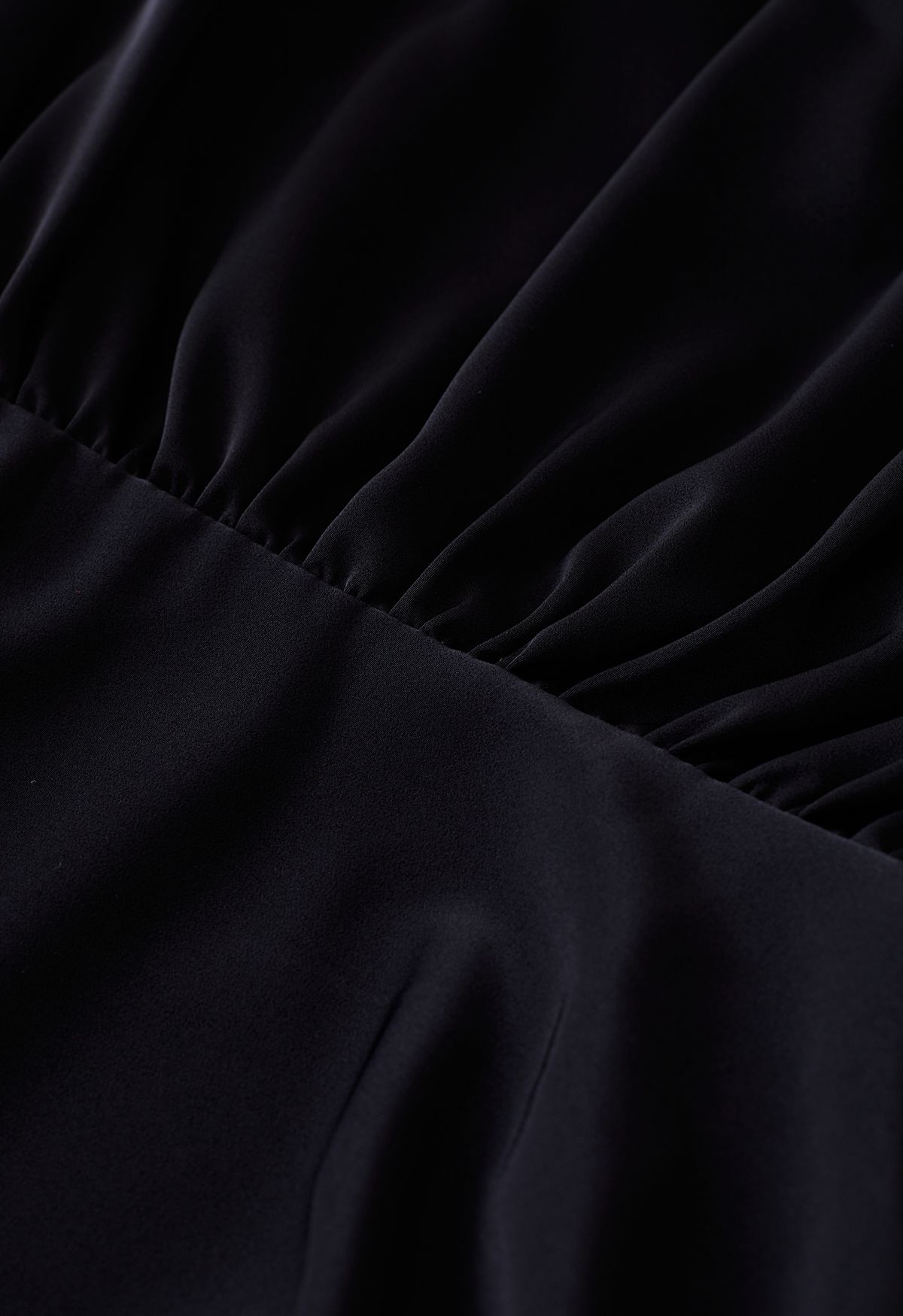 Vestido de satén fruncido con cuello vuelto y hombros acolchados en negro