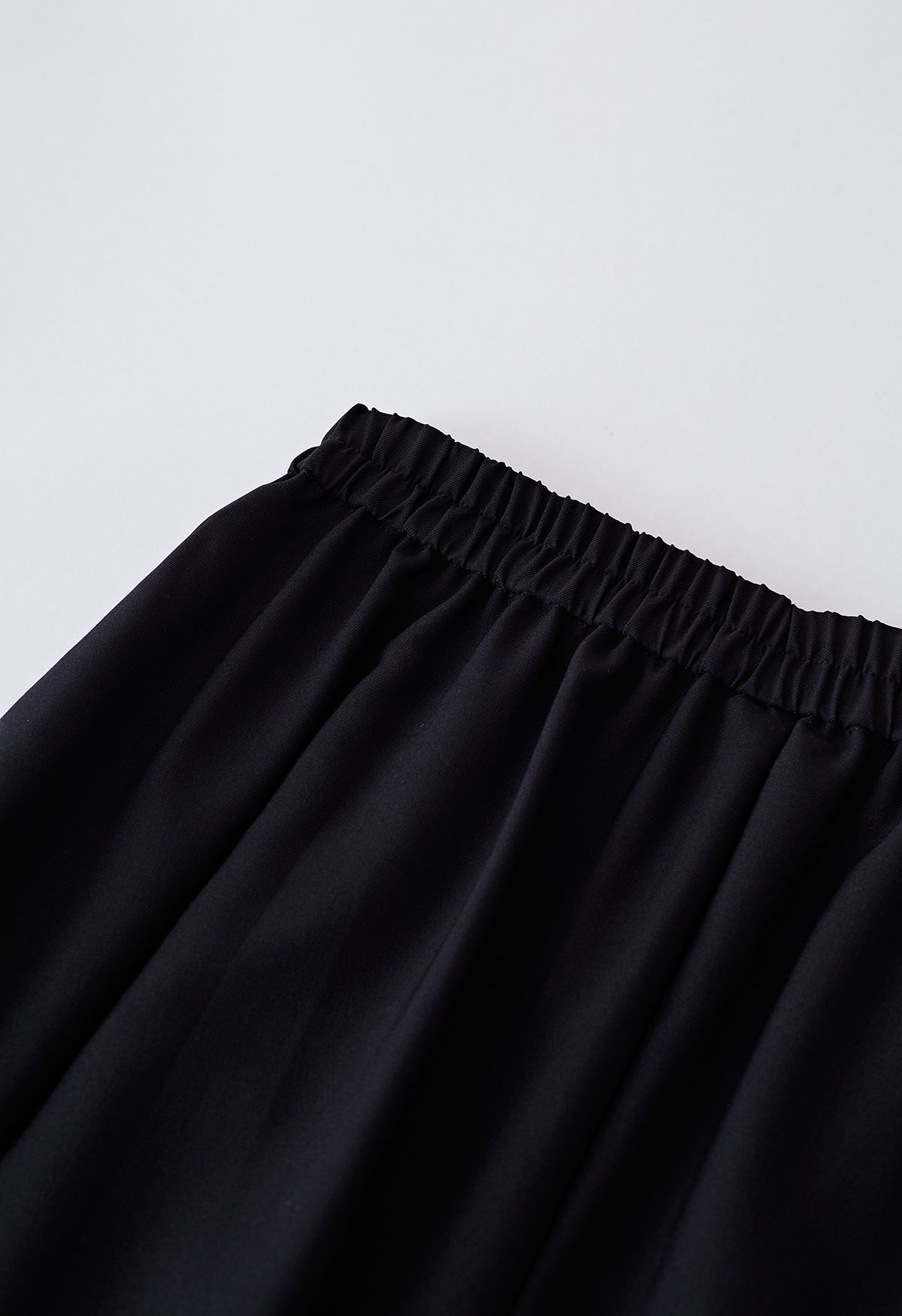 Falda evasé plisada con detalle de costuras en negro