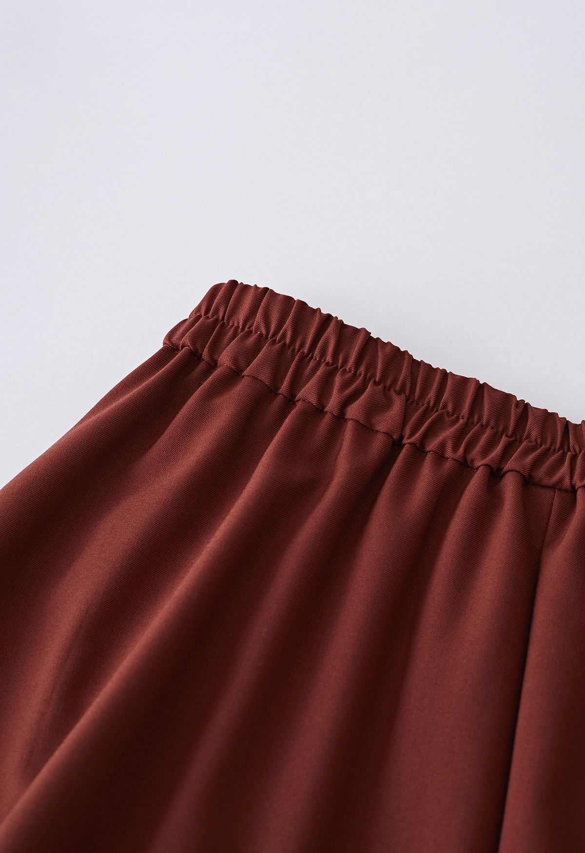 Falda evasé plisada con detalle de costuras en rojo óxido