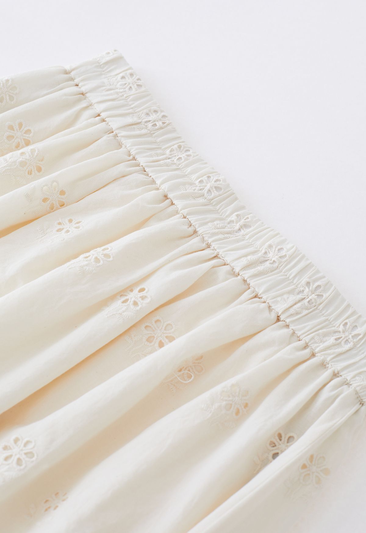 Falda larga con abertura lateral y ojales bordados en color crema