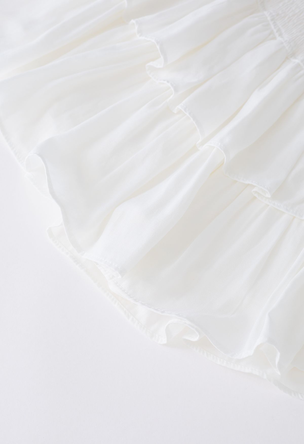 Minifalda con cintura fruncida y volantes escalonados en blanco