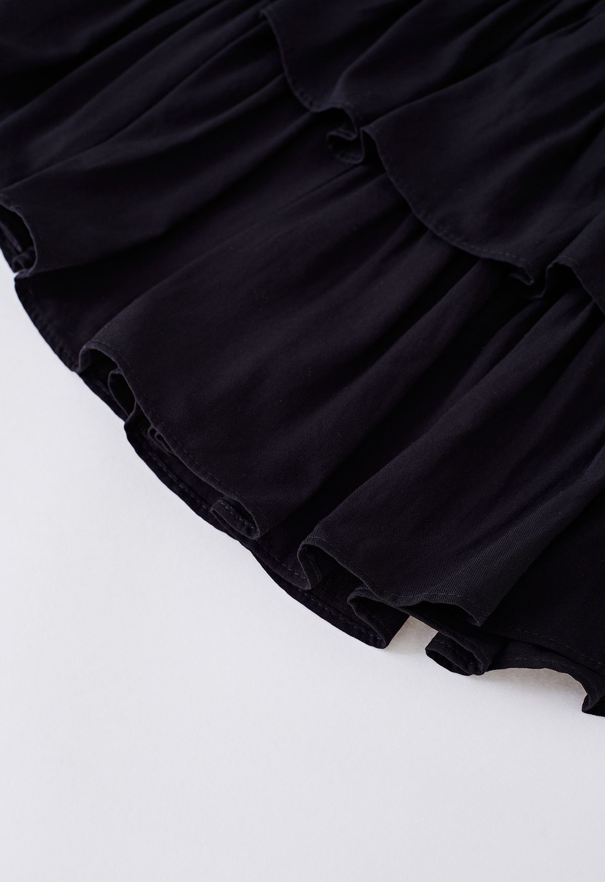 Minifalda con cintura fruncida y volantes escalonados en negro