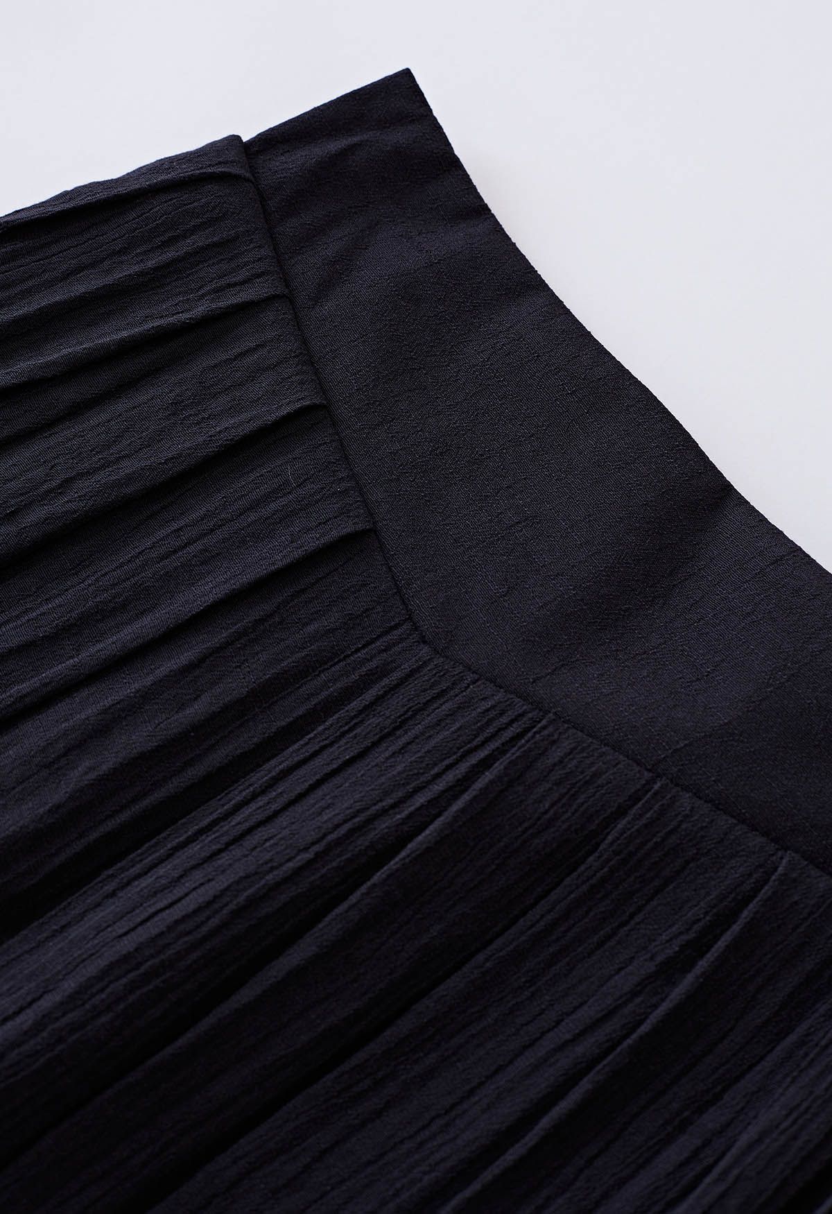 Pantalones anchos plisados con cintura anudada en negro