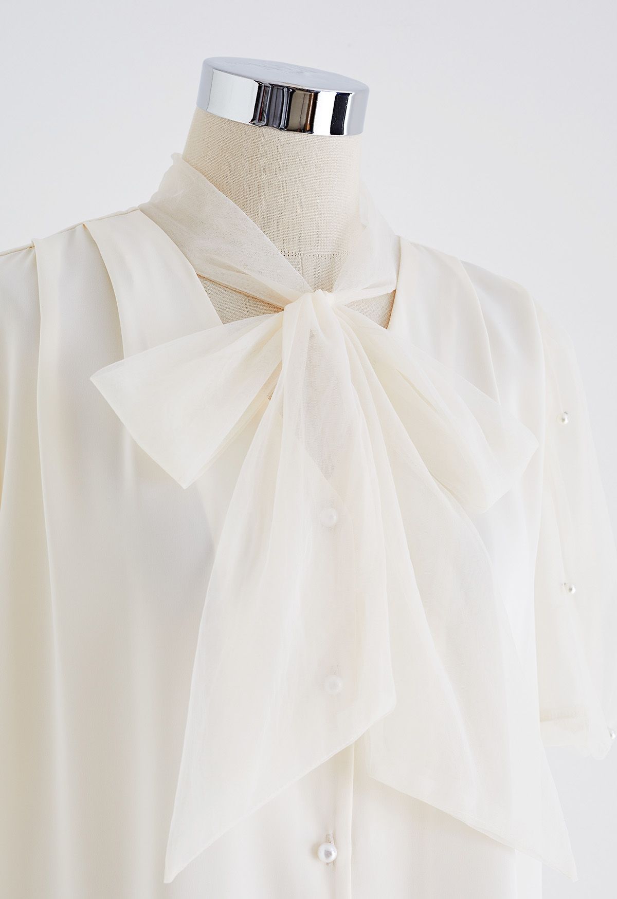 Camisa de satén empalmada con manga de malla nacarada y lazo en color crema