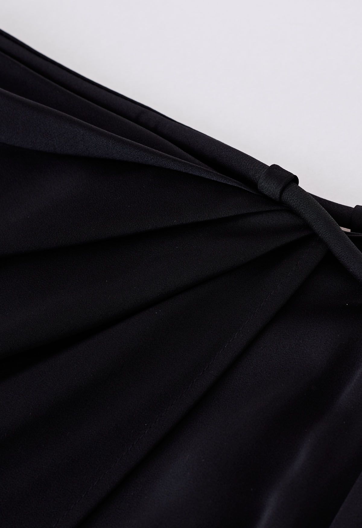 Falda midi de satén con solapa asimétrica y cintura anudada en negro