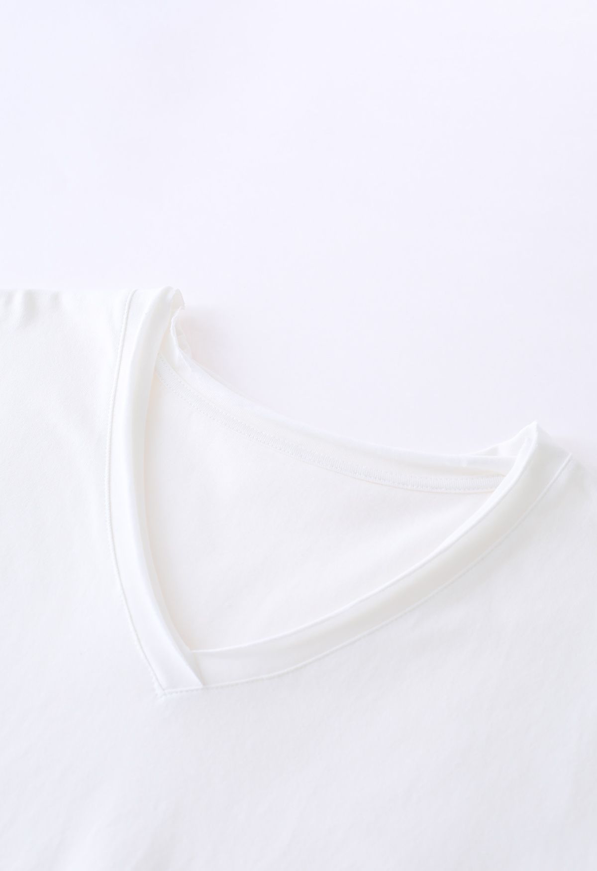 Camiseta de corte crudo con bolsillo de parche y cuello en V en blanco
