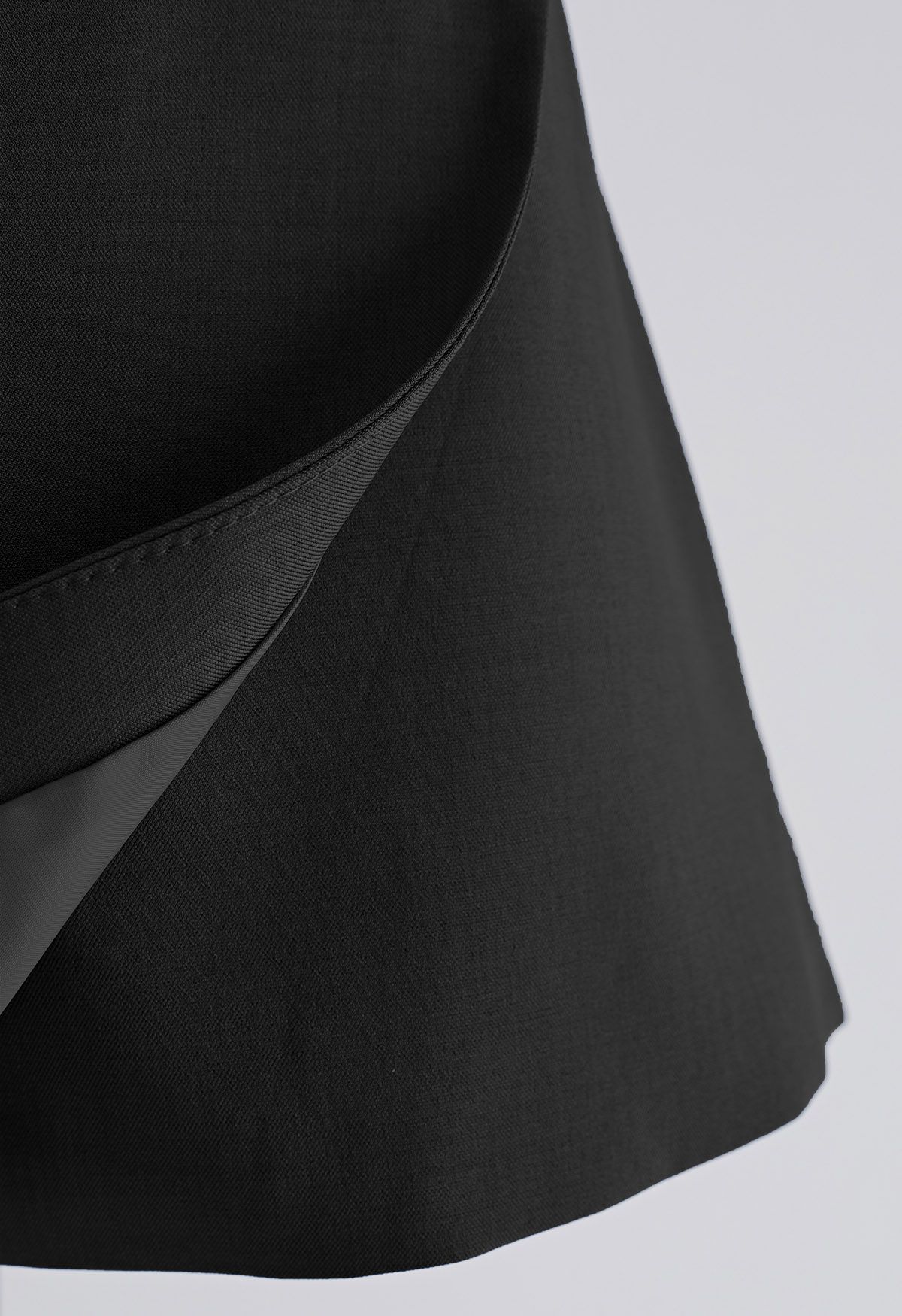 Falda pantalón con cinturón y solapa de línea de corte irregular en negro
