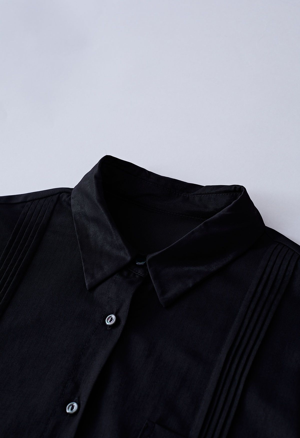 Elegante camisa con botones y detalle de pliegues en negro