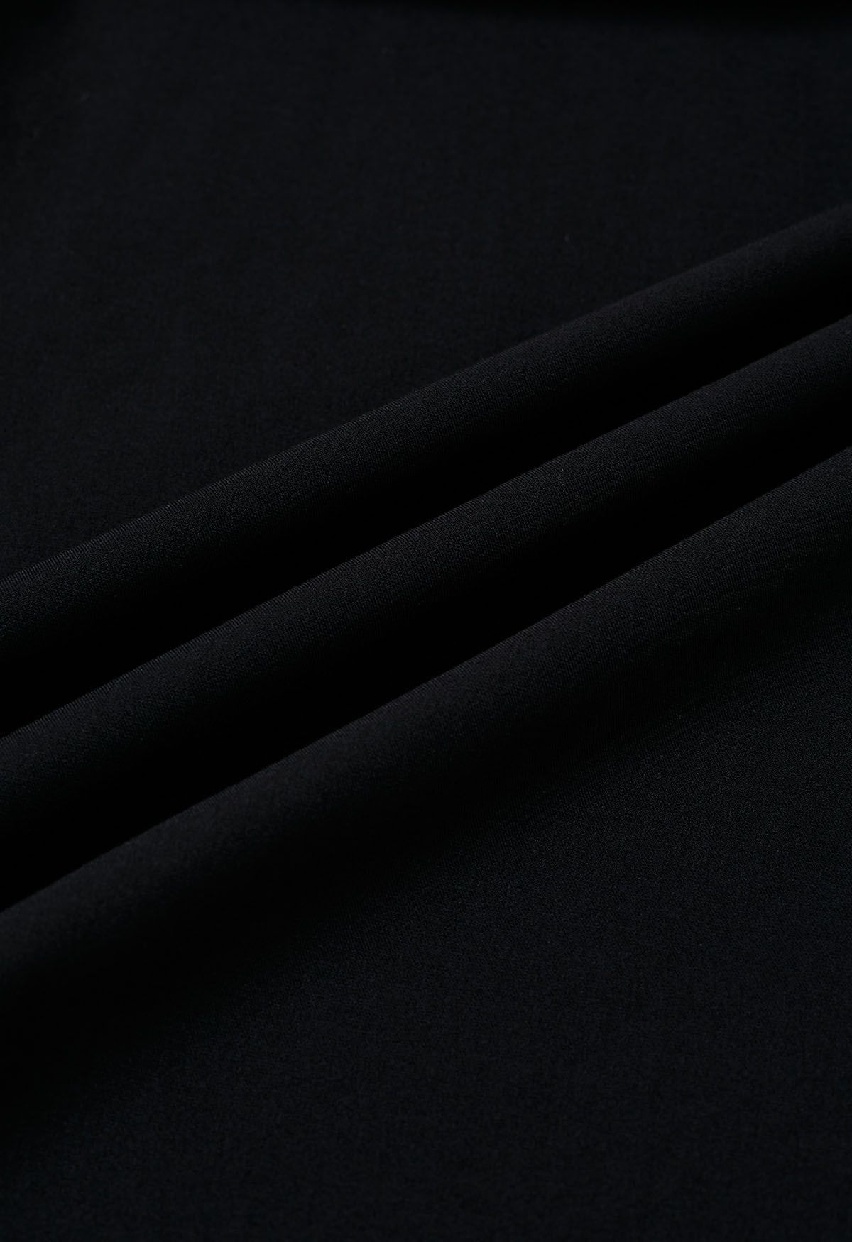 Falda acampanada plisada decorada con botones en negro