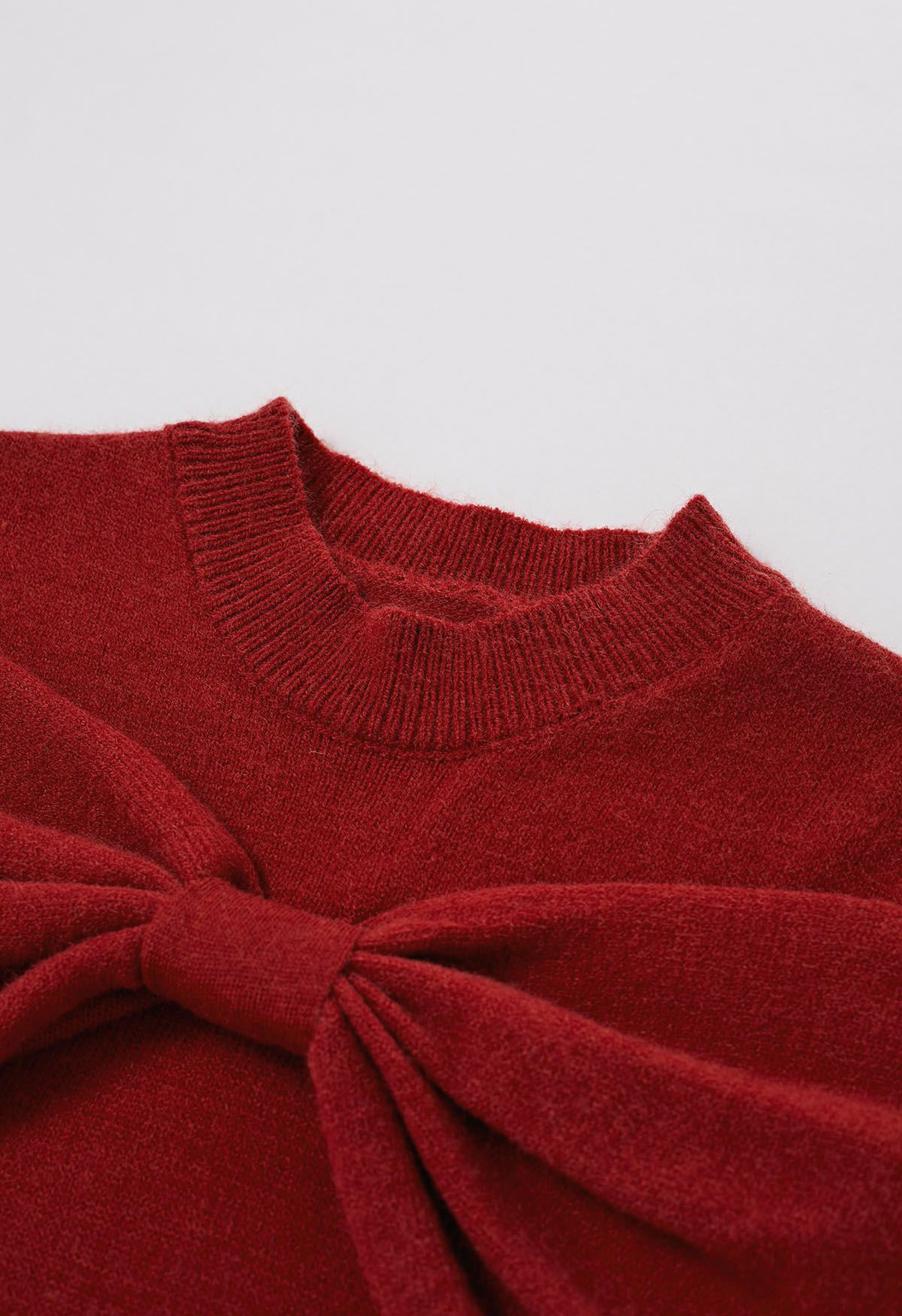 Suéter de punto con hombros descubiertos y lazo en rojo
