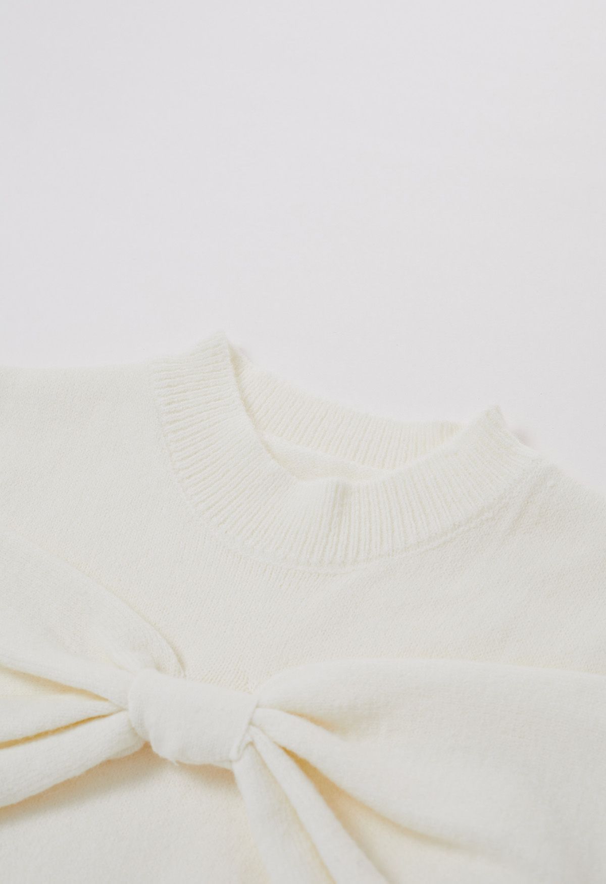 Suéter de punto con hombros descubiertos y lazo en color crema