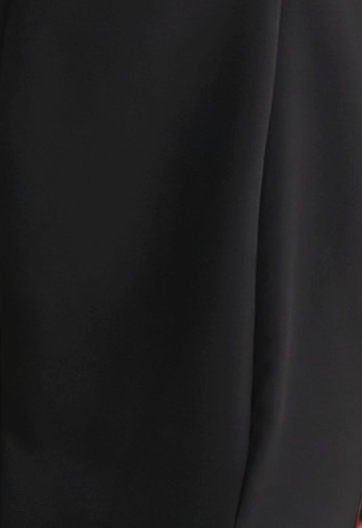 Vestido negro con abertura en el escote y ribete de plumas