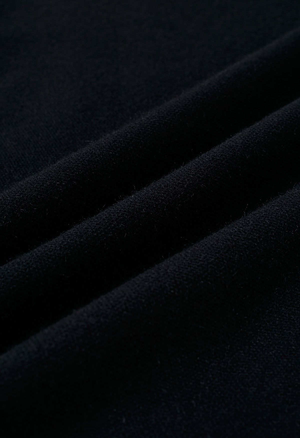 Poncho de punto con dobladillo dividido y mangas de piel sintética en negro