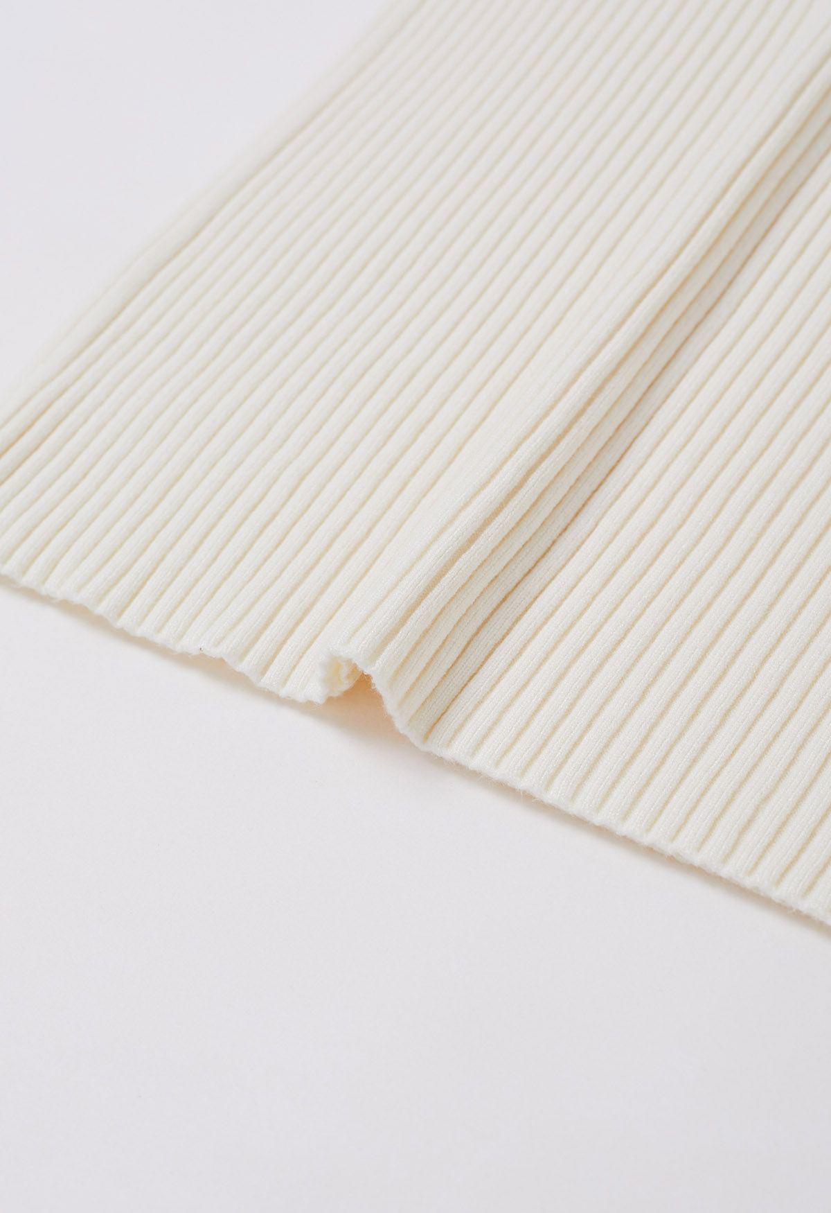Jersey versátil de punto acanalado con cuello alto en color marfil