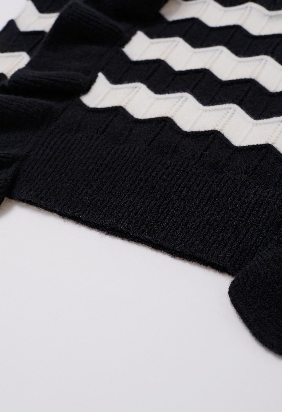 Suéter de punto con rayas onduladas y ribete de volantes en negro