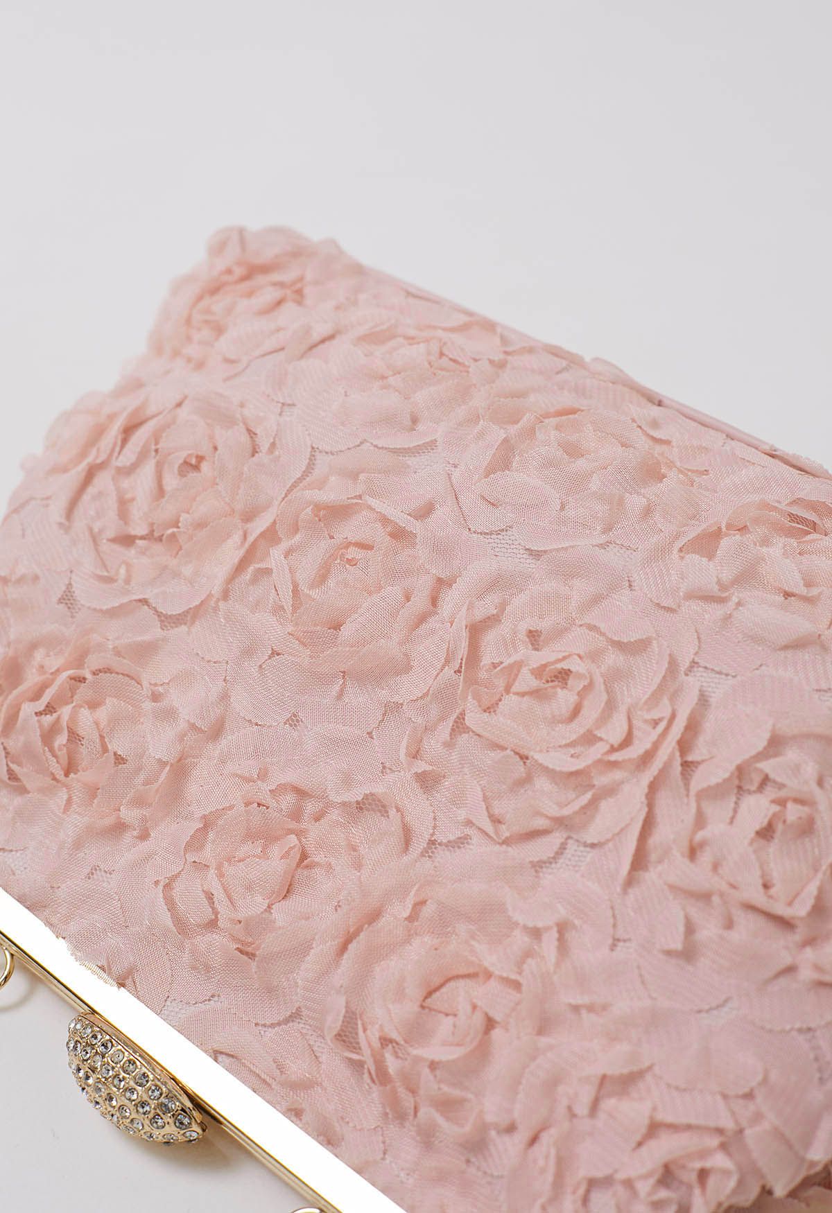 Elegante bolso de mano con pétalos de rosa en rosa