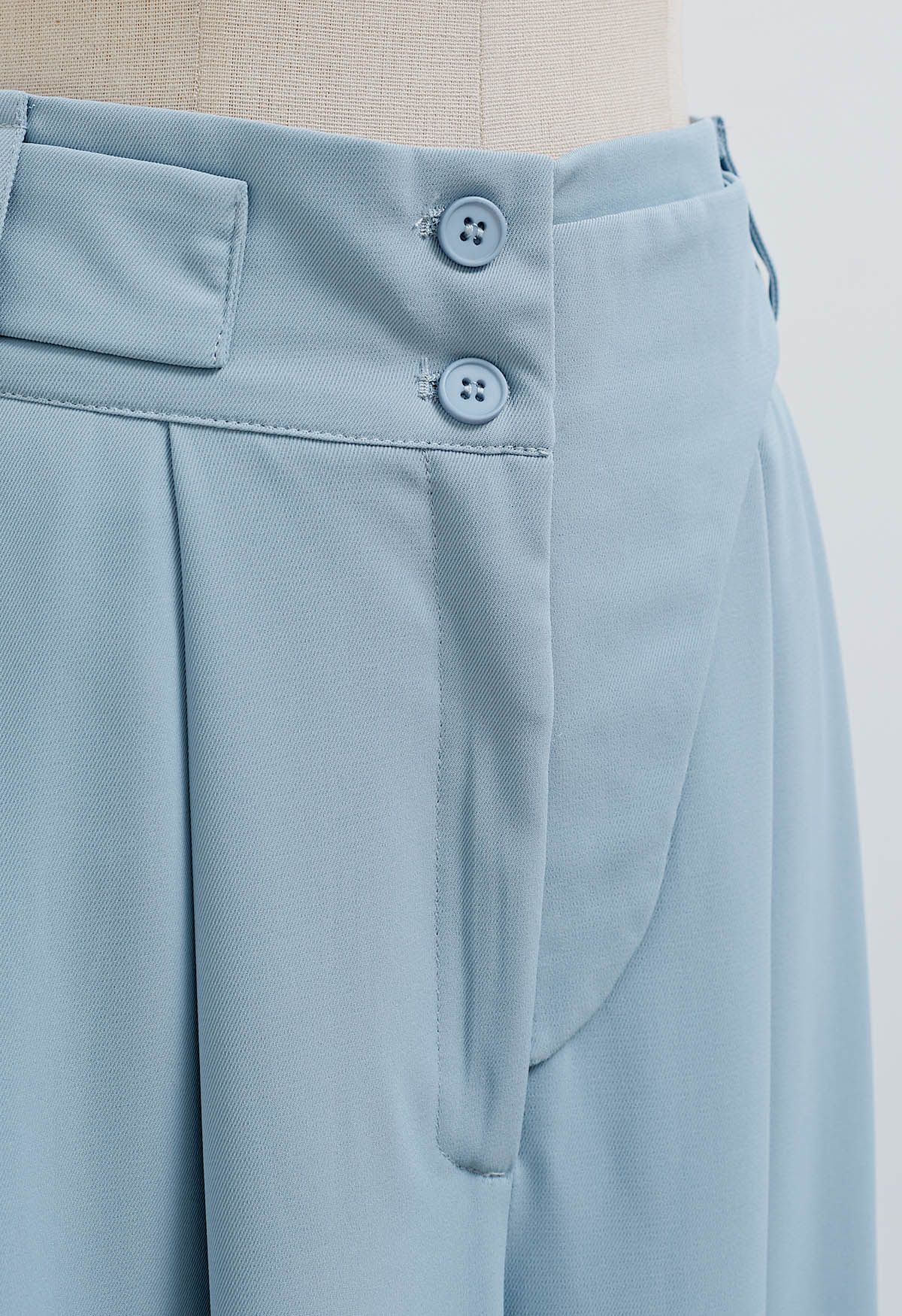 Pantalón ancho plisado con cinturón decorativo en azul