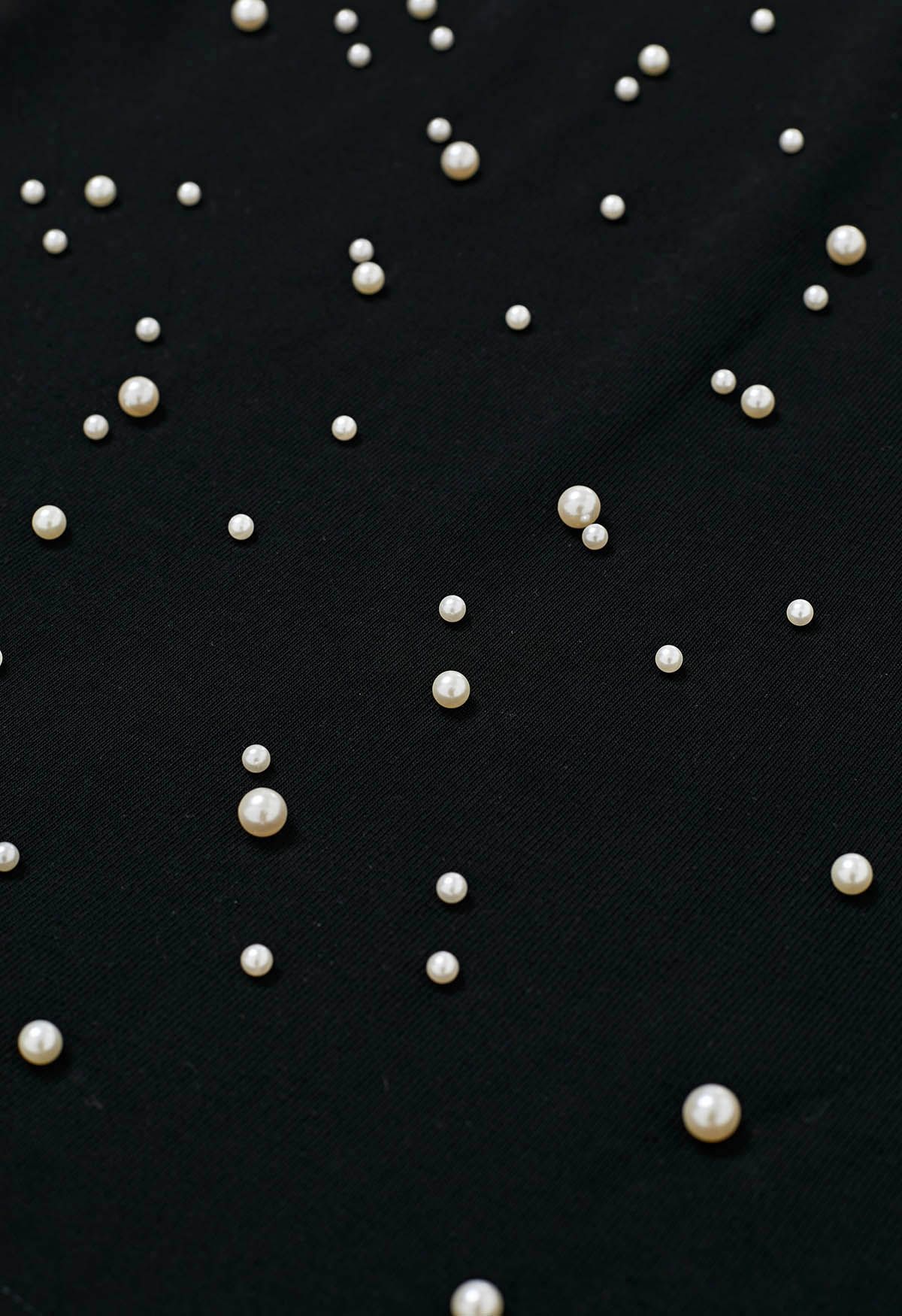 Camiseta sofisticada con ribete de perlas en negro