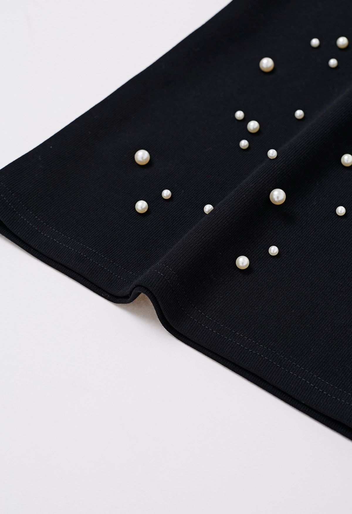 Camiseta sofisticada con ribete de perlas en negro