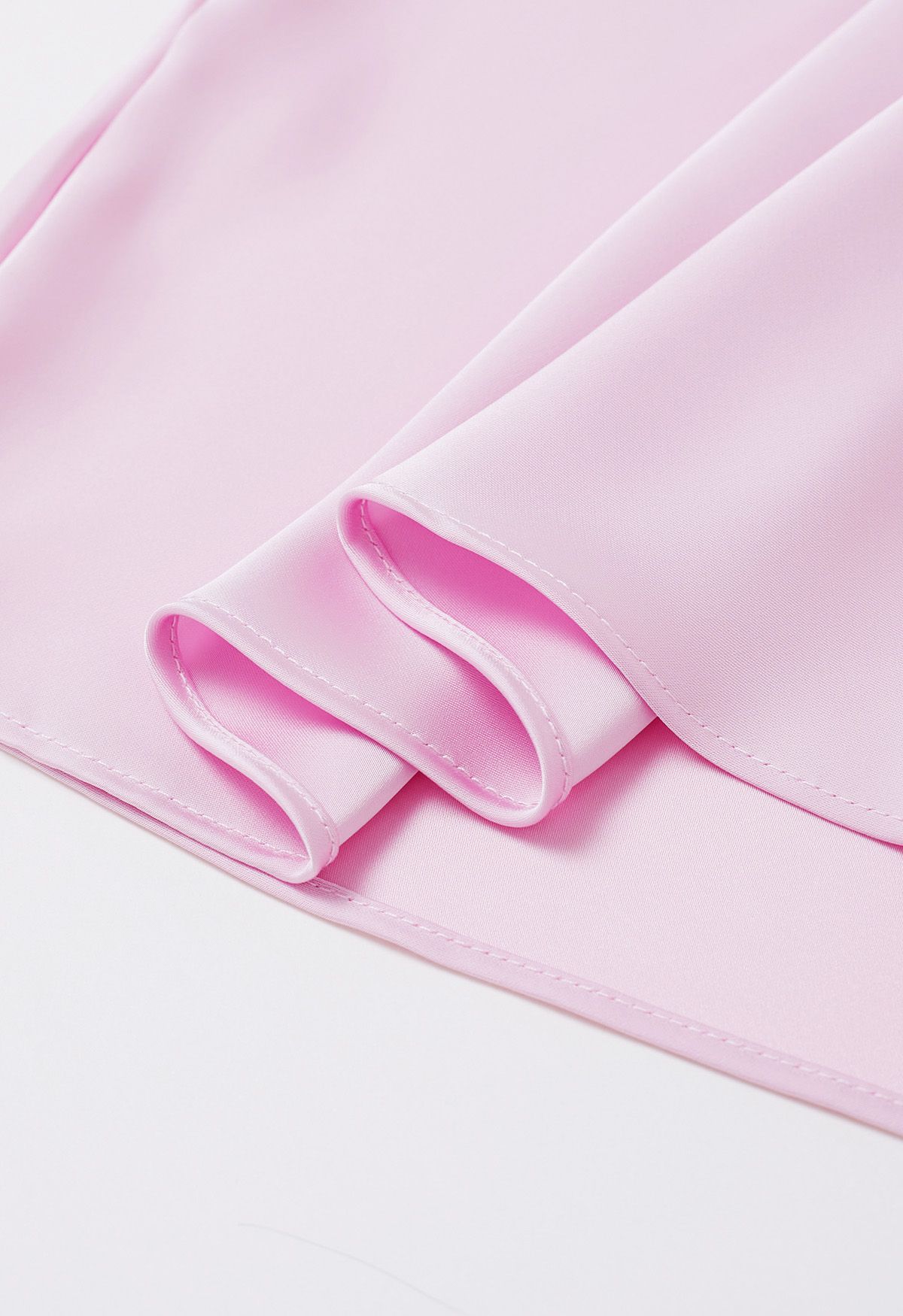Top asimétrico de manga larga de satén fruncido en rosa