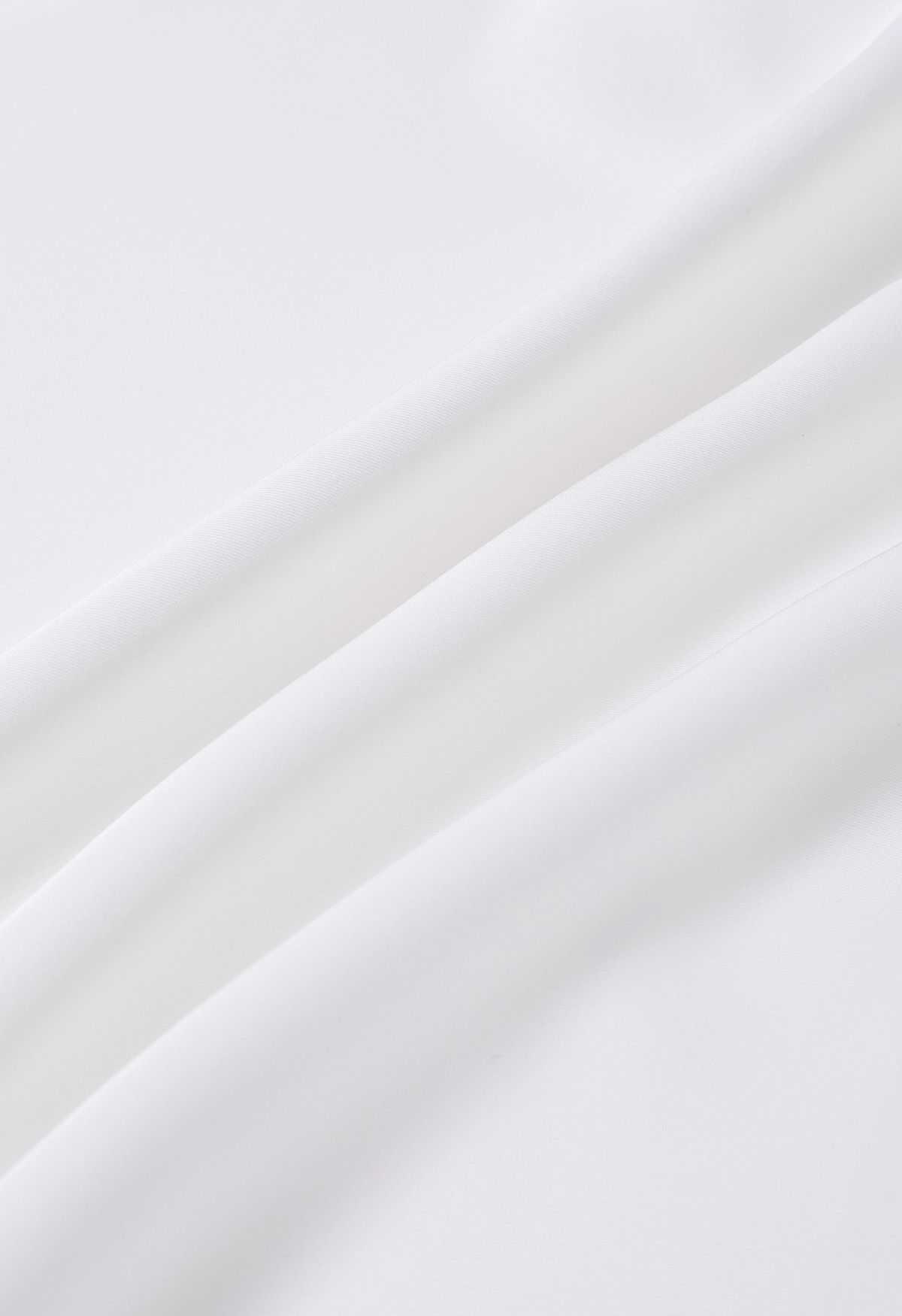 Top asimétrico de manga larga de satén fruncido en blanco