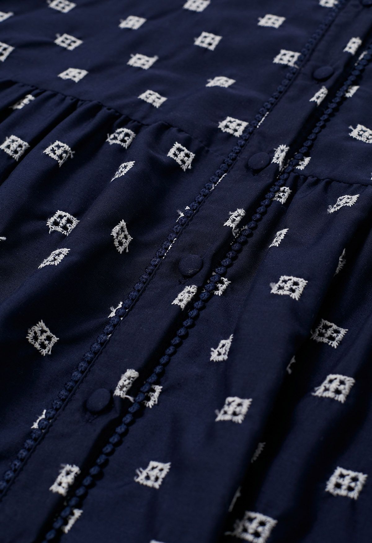 Vestido camisero de algodón bordado con ojales y cintura anudada en azul marino