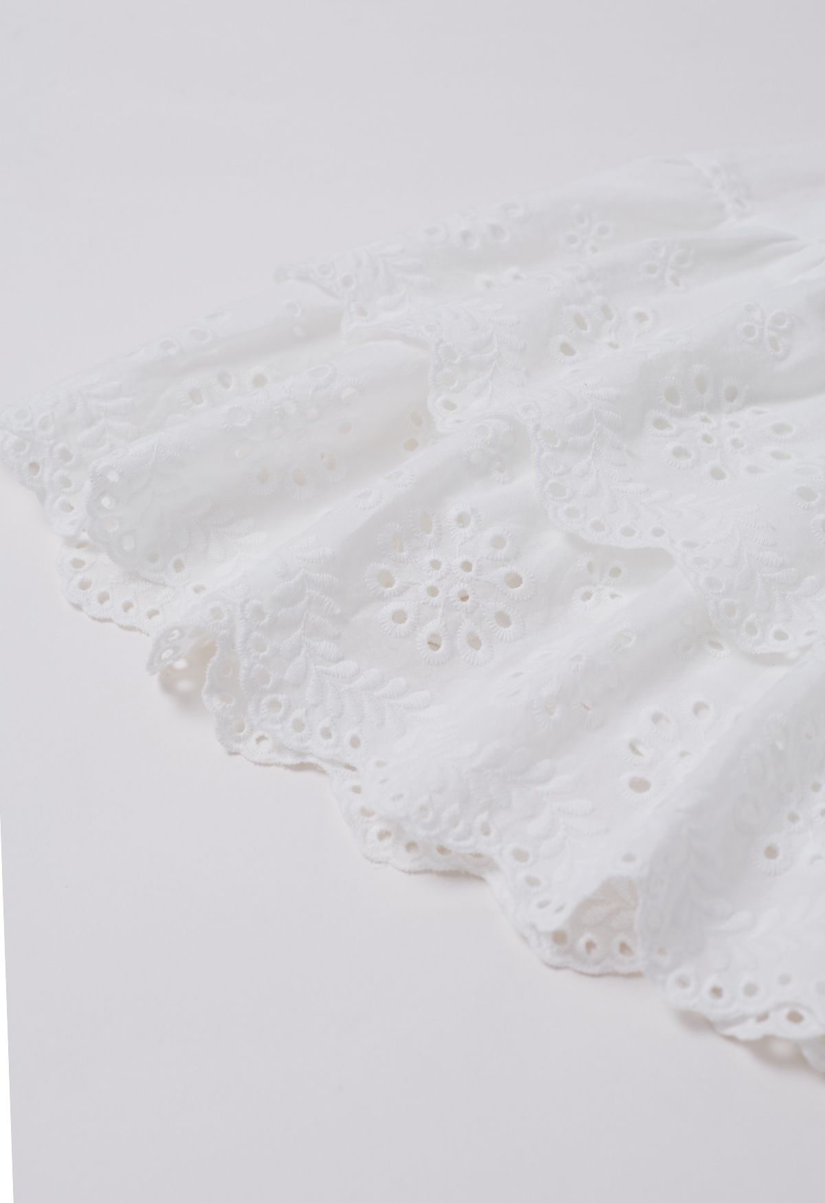 Minifalda escalonada con bordado de ojales en blanco