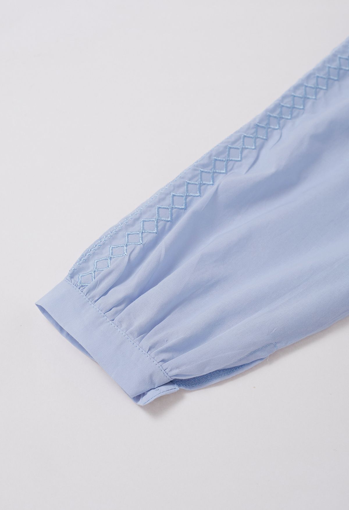 Top de algodón con bordado de hilo y borlas en azul