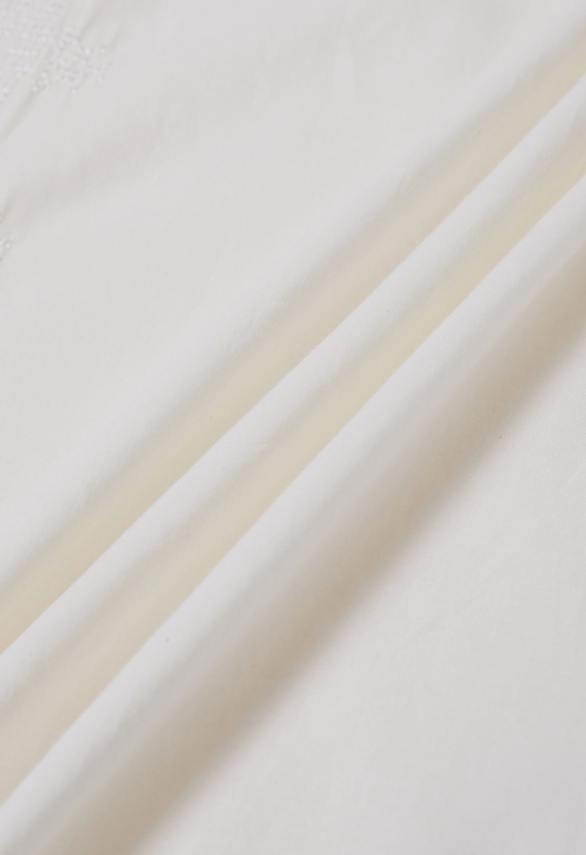 Top de algodón con bordado de hilo y borlas en blanco