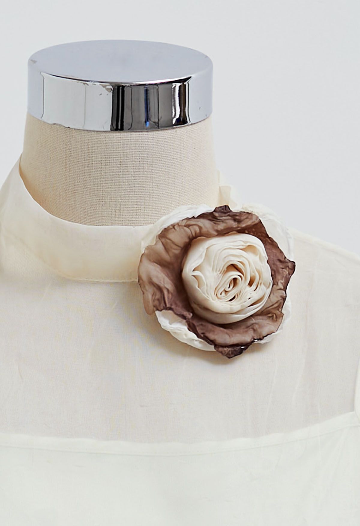Top transparente con textura y mangas abullonadas con broche de rosas en color crema