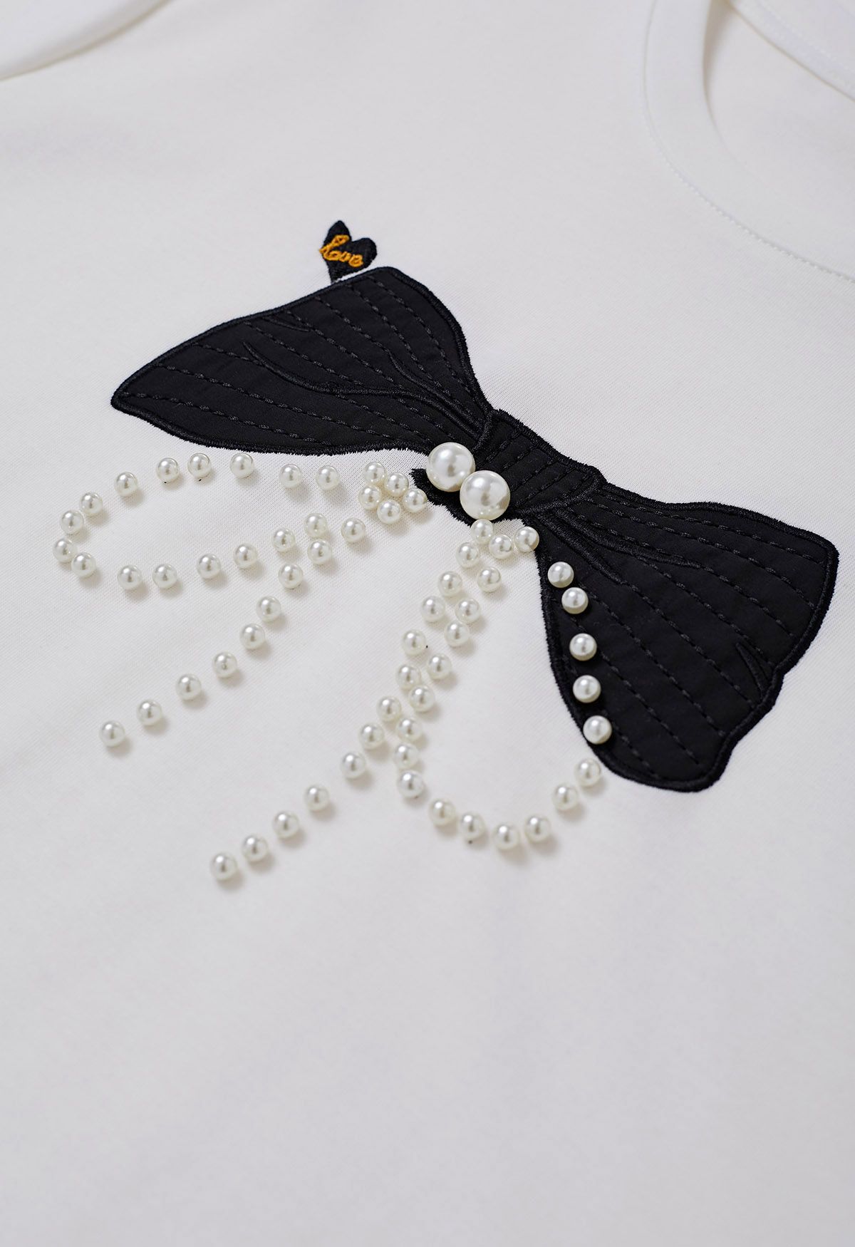 Camiseta con adornos de perlas y estampado de lazo en blanco