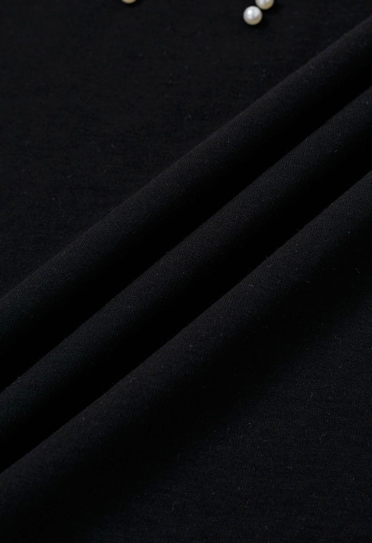 Camiseta negra con adornos de perlas y estampado de lazo