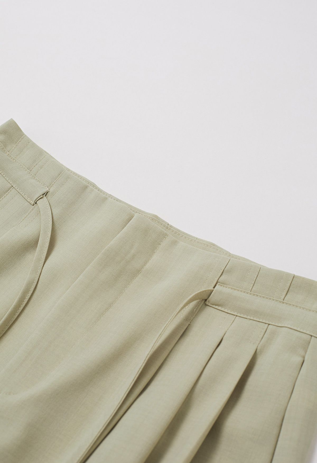 Pantalones anchos con pliegues y cordón anudado en verde guisante