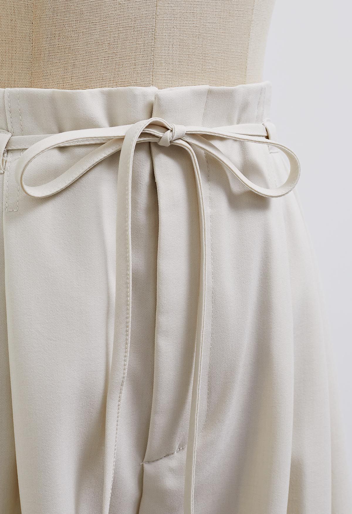Pantalones anchos con pliegues y cordón anudado en marfil