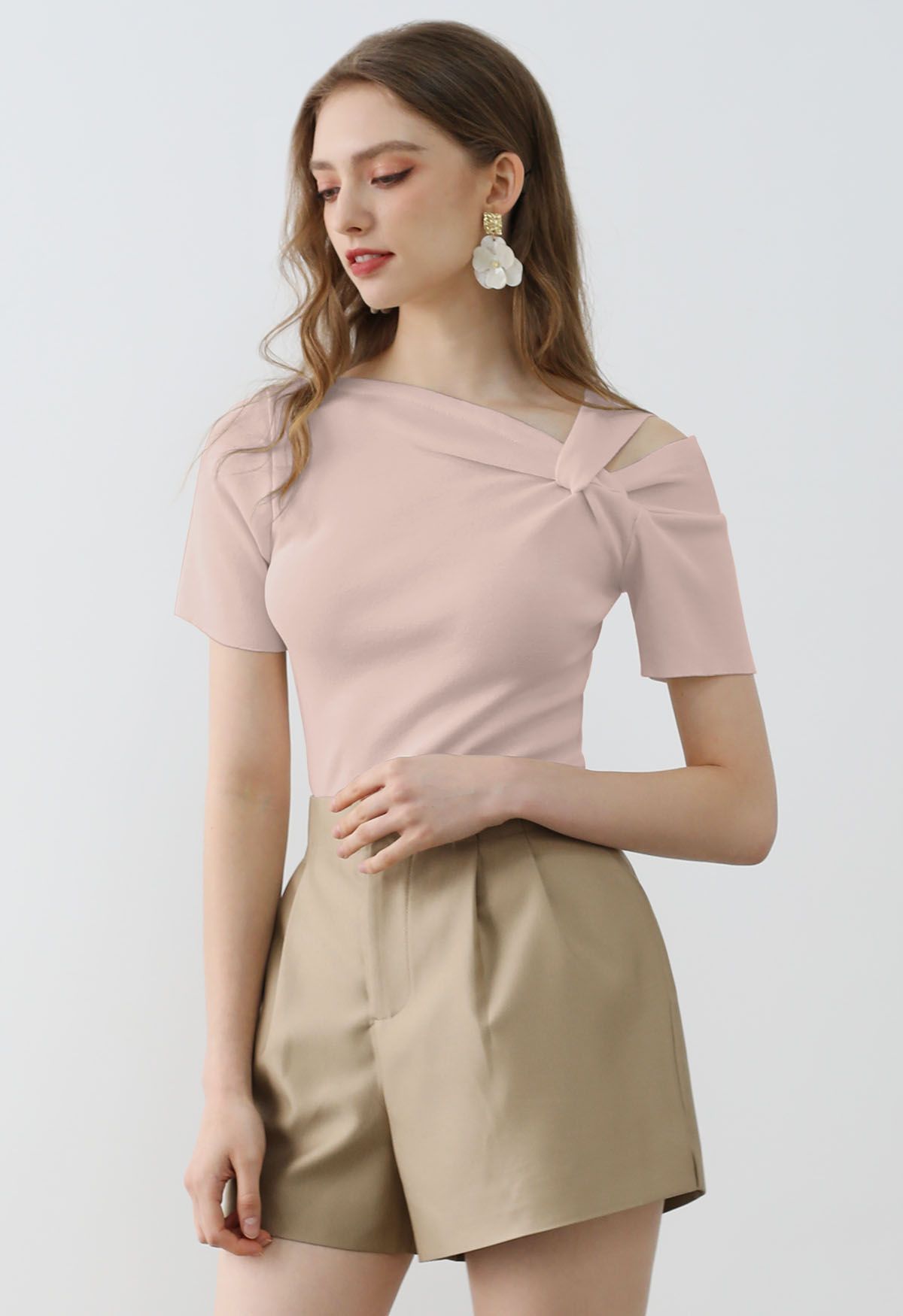 Elegante top de punto elástico con hombros anudados en rosa