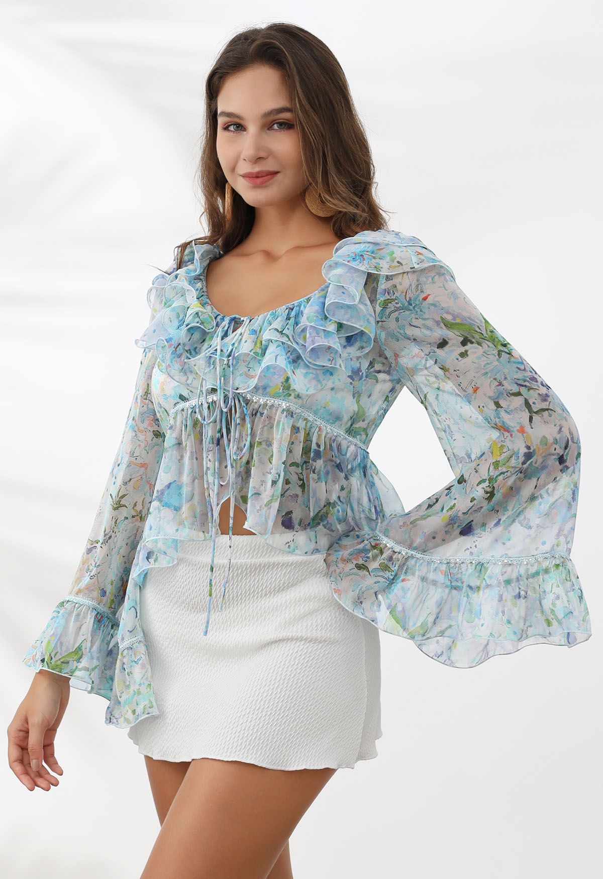 Top transparente con mangas acampanadas y volantes florales de acuarela en azul